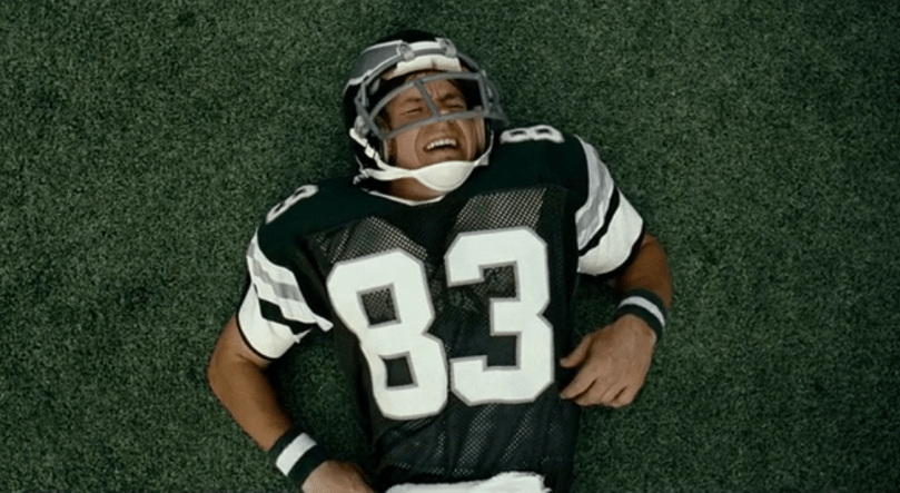 Football player laying on the turf after getting hit
